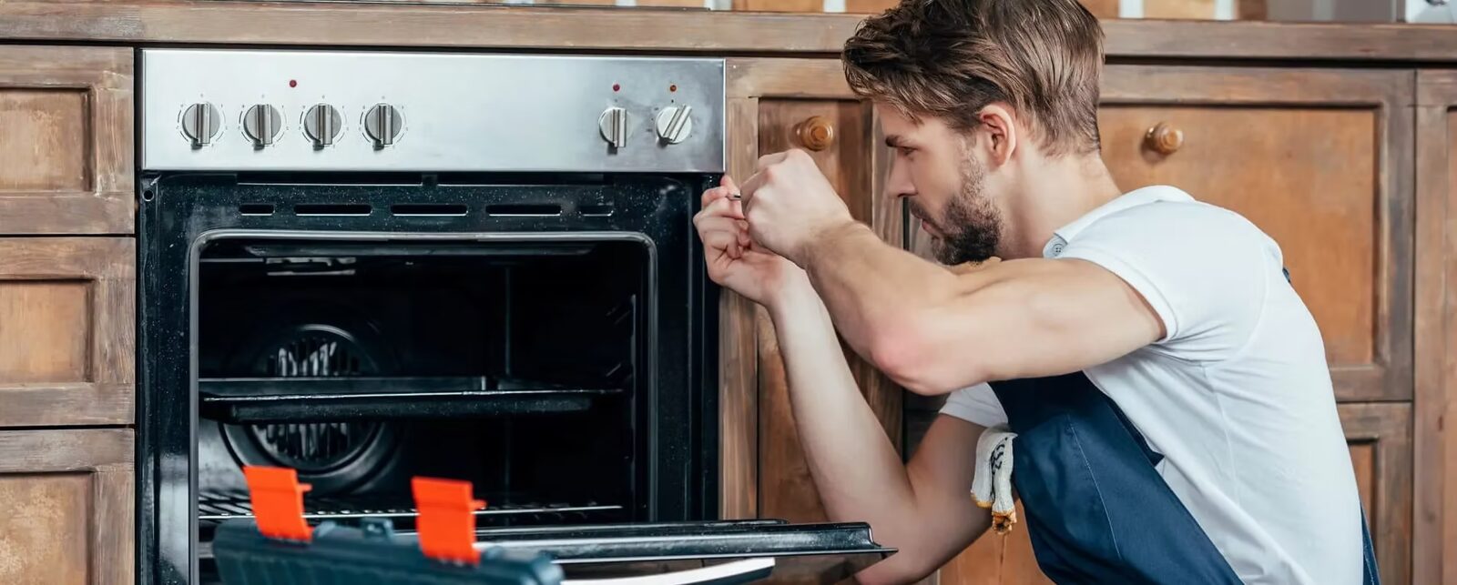 Técnico da JR Fogões ajustando um forno de embutir em uma cozinha residencial